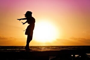 Woman on shoreline at sunset